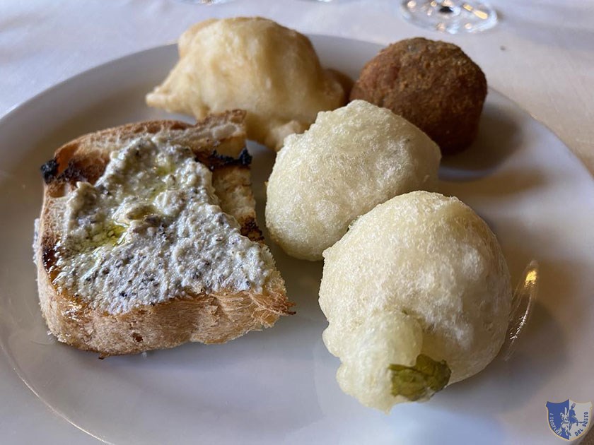 Raviolo fritto con ricotta di Montella bruschetta con ricotta e tartufo nero zeppoline con rucole e polpettina di melanzane