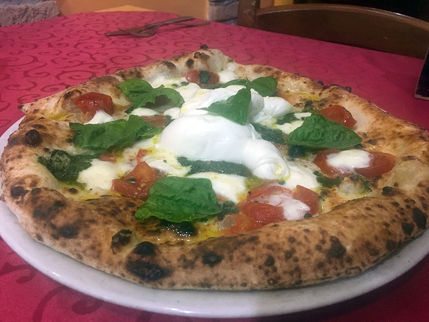 Pizza con pomodorini del piennolo rosso pesto di basilico artigianale burrata di bufala e mozzarella di bufala