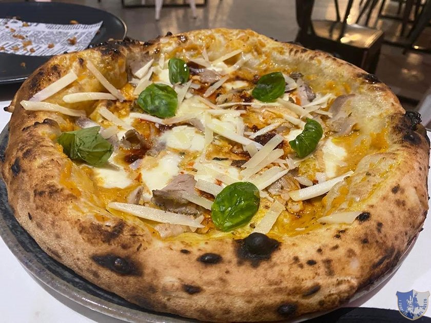 Pizza con crema di zucca porchetta di Ariccia gocce di Nduja e cacioricotta