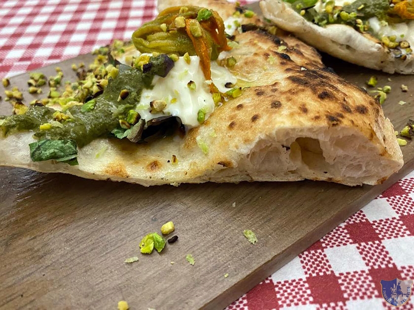 La bianca con stracciatella fiori di zucca granella di pistacchio pesto e zest di limone