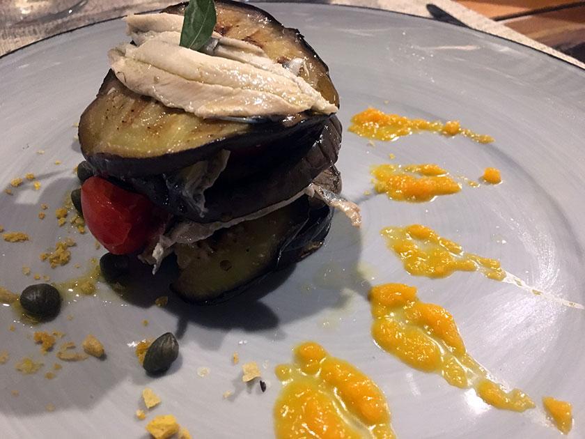 Tortino di melanzane con alici pomodoro e capperino occhiello alla crema di zucca