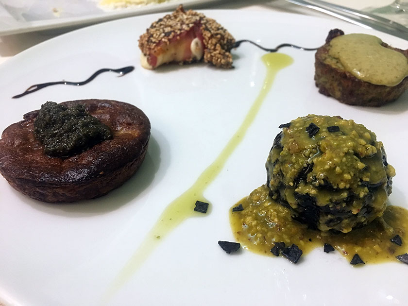 Fruttatina di funghi con emulsione di ortiche riso venere con crema di pistacchi flan di carciofi con salvia e formaggio in crosta di sesamo e speck