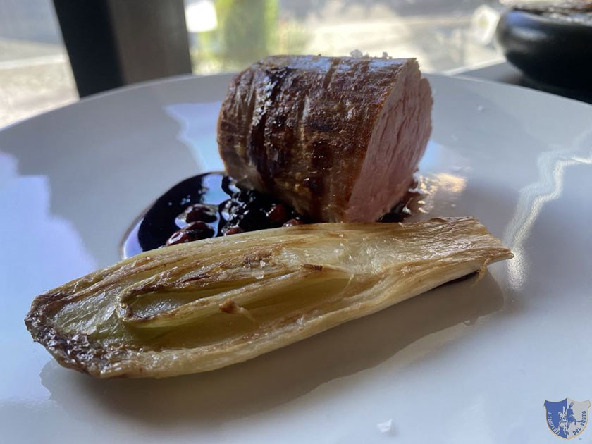 Filetto di maiale scottato in padella con fondo ai frutti rossi e indivia brasata