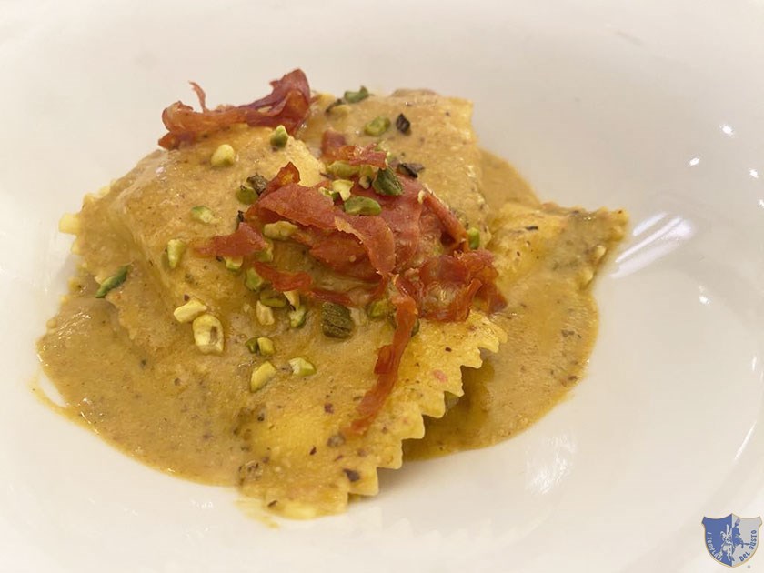 Ravioli di burrata con pomodorino giallo e rosso ventricina croccante e pesto di pistacchio