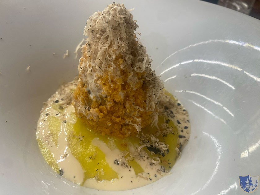 Arancino di risotto con porcini salsiccia e pecorino Carmasciano su vellutata di zafferano e tartufo estivo