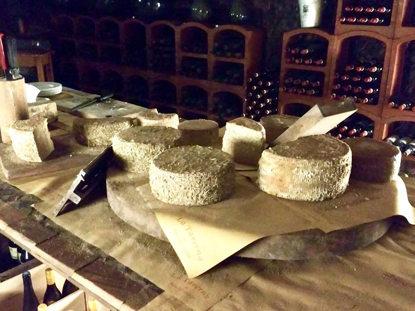 Un angolo della cantina con un trionfo di formaggi