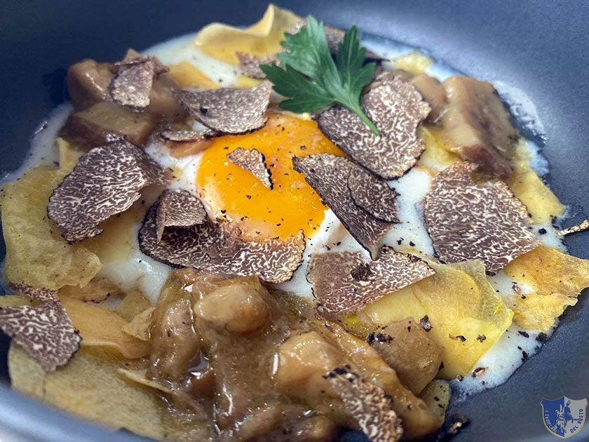 Uovo scomposto su fonduta di pecora con funghi porcini tarfuto nero e chips di patate