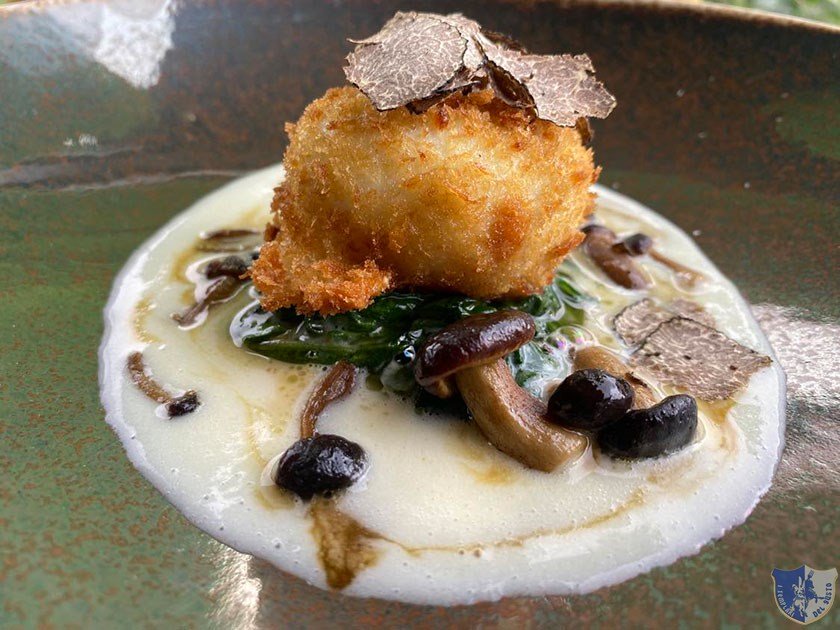 Uovo croccante con fonduta di parmigiano reggiano tartufo nero funghi pioppini spinaci saltati al burro e jus di manzo