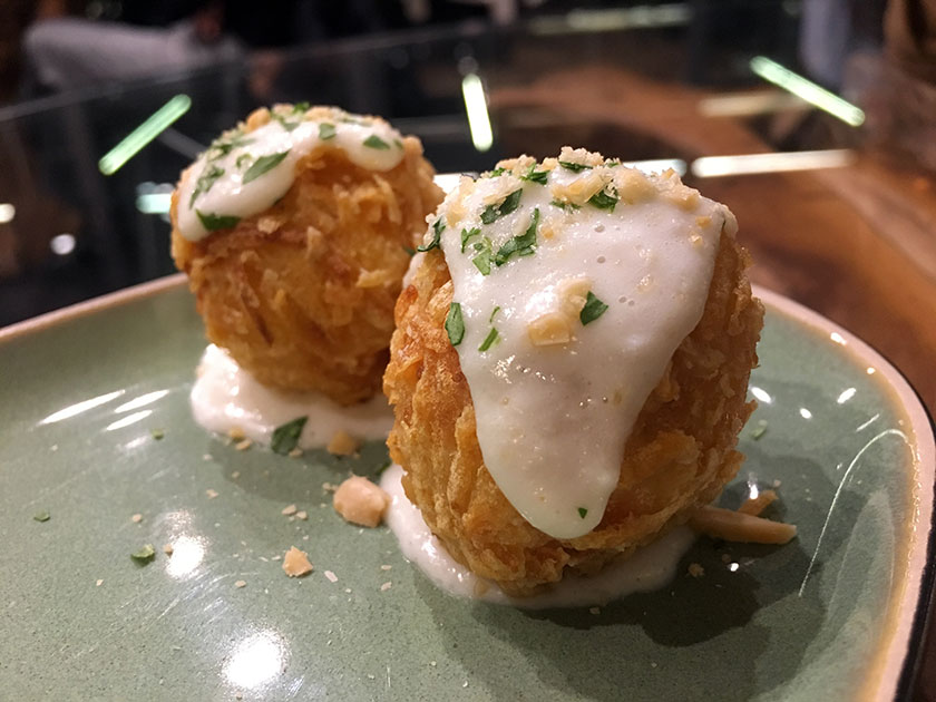 Polpette di salmone in crosta di patata con panna acida al rafano e battuto di rucola e mandorle