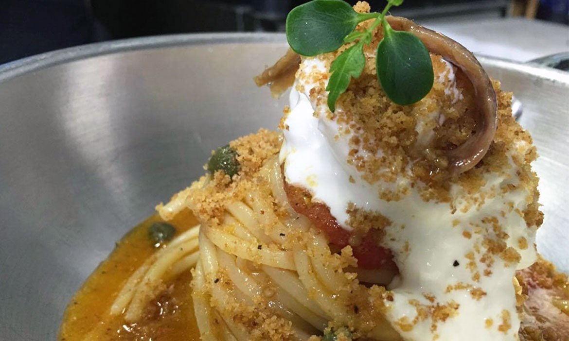 Spaghetti con alici, capperi, pomodoro, stracciatella e pane fritto