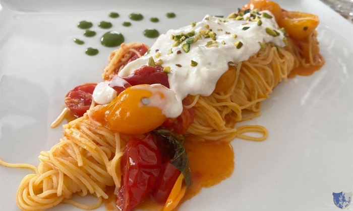 Tagliolini con pomodorini rossi e gialli, stracciatella di bufala e granella di pistacchio